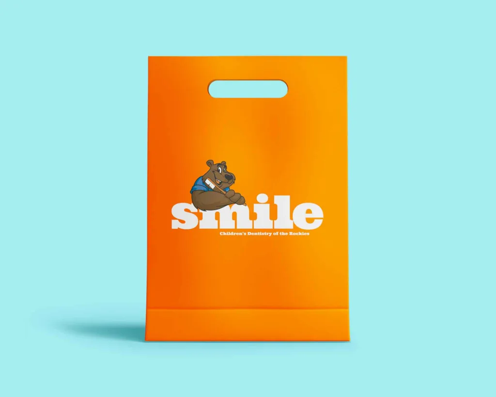 Pediatric Dentist orange Gift Bag with smile and a bear mascot